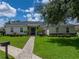 Charming single-story home featuring a landscaped yard with brick walkway at 128 Melissa Trl, Auburndale, FL 33823