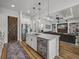 Modern kitchen with island seating, stainless appliances, and an adjacent living area at 128 Melissa Trl, Auburndale, FL 33823