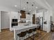 Spacious kitchen with a large island, stainless steel appliances, custom cabinets, and pendant lighting at 128 Melissa Trl, Auburndale, FL 33823
