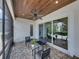 Inviting screened-in patio with ceiling fan, brick flooring, wood ceiling, and sliding glass doors at 128 Melissa Trl, Auburndale, FL 33823