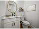 Charming powder room features a white vanity with marble countertop and a gold-framed mirror at 128 Melissa Trl, Auburndale, FL 33823