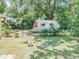 Fenced backyard featuring ample space, mature trees, and a vintage camper at 132 Kinstle Ave, Auburndale, FL 33823