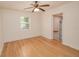 Bedroom features hardwood floors, neutral walls, a ceiling fan, and a bright window at 132 Kinstle Ave, Auburndale, FL 33823