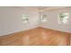 A bright, open bedroom featuring hardwood floors and three windows at 132 Kinstle Ave, Auburndale, FL 33823
