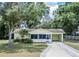 Charming single-story home featuring a landscaped front yard and driveway with a carport at 132 Kinstle Ave, Auburndale, FL 33823
