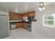 Bright kitchen with stainless steel appliances, wood cabinetry, tile backsplash, and a ceiling fan at 132 Kinstle Ave, Auburndale, FL 33823