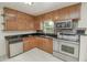 Cozy kitchen featuring wood cabinets, granite countertops, stainless steel appliances, and tile flooring at 132 Kinstle Ave, Auburndale, FL 33823