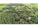 Scenic aerial shot showing wooded acreage with scattered homes and green fields at 15345 Angus Rd, Polk City, FL 33868