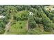 Scenic aerial view of a property surrounded by dense woods and vibrant greenery, showcasing a private retreat at 15345 Angus Rd, Polk City, FL 33868