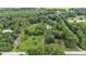 Picturesque aerial shot of a home nestled amongst lush trees, complemented by an expansive lawn area at 15345 Angus Rd, Polk City, FL 33868