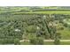 Scenic aerial shot showing wooded acreage with scattered homes and green fields at 15345 Angus Rd, Polk City, FL 33868