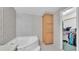 Bathroom with a bathtub and a storage cabinet with floral wallpaper at 15345 Angus Rd, Polk City, FL 33868