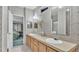 Bathroom with double sinks and a neutral countertop with floral wallpaper at 15345 Angus Rd, Polk City, FL 33868