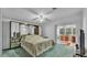 Bedroom with carpet, ceiling fan, mirrored closet, and a sliding glass door to the sunroom at 15345 Angus Rd, Polk City, FL 33868