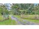 Inviting driveway with gated entrance, mature trees, and lush greenery at 15345 Angus Rd, Polk City, FL 33868