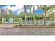 Charming single-story home featuring a welcoming porch, palm trees, and lush landscaping at 15345 Angus Rd, Polk City, FL 33868