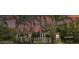 Attractive single-story home with a covered porch, set amidst a backdrop of palm trees and a picturesque sunset at 15345 Angus Rd, Polk City, FL 33868