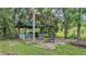 Charming outdoor gazebo nestled among trees with decorative brick and white picket fence at 15345 Angus Rd, Polk City, FL 33868