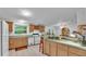 Bright kitchen featuring wood cabinets, modern appliances, and a breakfast bar at 15345 Angus Rd, Polk City, FL 33868
