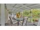 Inviting covered porch with table, chairs, and peaceful view of lush landscaping at 15345 Angus Rd, Polk City, FL 33868