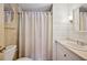 Bathroom with white tile walls, decorative seashells, a white vanity, and shower with curtain at 1610 Reynolds Rd # 214, Lakeland, FL 33801