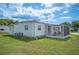 Exterior view of the residence featuring a well-maintained yard and screened-in patio at 1610 Reynolds Rd # 214, Lakeland, FL 33801