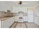 Well-lit kitchen with white cabinets and appliances, complemented by tile flooring at 1610 Reynolds Rd # 214, Lakeland, FL 33801