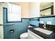 Bright bathroom with black granite sink countertop and retro blue tile at 1720 Park Dr, Lakeland, FL 33803