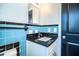 This bathroom is brightly lit, featuring blue tiling, a white sink and black countertop at 1720 Park Dr, Lakeland, FL 33803