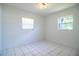 This bright bedroom features two windows and tile flooring with neutral paint at 1720 Park Dr, Lakeland, FL 33803