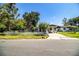 A cozy single-story home with a well-kept lawn, a carport, and a classic white picket fence at 1720 Park Dr, Lakeland, FL 33803