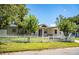 Charming home featuring a white picket fence and mature trees enhancing the curb appeal at 1720 Park Dr, Lakeland, FL 33803