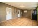 Neutral room with tiled floor, two white doors and dark colored fridge at 1720 Park Dr, Lakeland, FL 33803