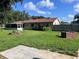 Spacious backyard featuring a brick fire pit, ample greenery and concrete slab at 2105 E Cherokee St, Bartow, FL 33830