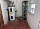 This basement features a hot water heater, concrete walls and floor, a metal shelf, and a small window at 2105 E Cherokee St, Bartow, FL 33830