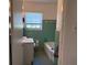 Bathroom with blue tile, classic fixtures and window at 2105 E Cherokee St, Bartow, FL 33830