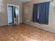 Bedroom with large window, closet with sliding mirrored doors and patterned floor at 2105 E Cherokee St, Bartow, FL 33830