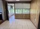 The dining room shows tile floors, wood paneling, and access to a screened porch at 2105 E Cherokee St, Bartow, FL 33830
