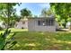 The home has a screened in back porch and a lush green yard at 215 W Valencia St, Lakeland, FL 33805