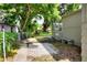 View of the home's side and backyard area with a gate leading to a paved patio and lush greenery at 215 W Valencia St, Lakeland, FL 33805