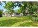Spacious backyard view with mature trees shading the green lawn, enhancing outdoor enjoyment at 215 W Valencia St, Lakeland, FL 33805