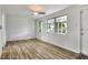 A stylish bedroom has a ceiling fan, laminate flooring, and two large windows at 215 W Valencia St, Lakeland, FL 33805