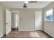 Bedroom featuring wood-look flooring, three doors, a ceiling fan, and a jalousie window at 215 W Valencia St, Lakeland, FL 33805