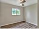 This bedroom has wood-look flooring, a window, and a modern ceiling fan at 215 W Valencia St, Lakeland, FL 33805