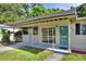 The front of the home has a covered porch area and a bright blue front door at 215 W Valencia St, Lakeland, FL 33805