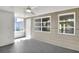 A neutral-toned sunroom featuring large windows, a ceiling fan, and an exit door at 215 W Valencia St, Lakeland, FL 33805