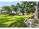 Well-maintained backyard with mature trees, lush green grass, and a black metal fence at 2208 Deerbrook Dr, Lakeland, FL 33811