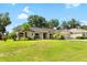Inviting single-story home with green lawn and mature landscaping, showcasing its charming curb appeal on a sunny day at 2208 Deerbrook Dr, Lakeland, FL 33811