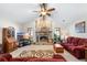 Cozy living room with a stone fireplace, ceiling fan, and ample seating, creating a warm and inviting atmosphere at 2208 Deerbrook Dr, Lakeland, FL 33811