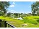 Scenic view of a serene pond surrounded by lush greenery and charming waterfront homes at 2208 Deerbrook Dr, Lakeland, FL 33811